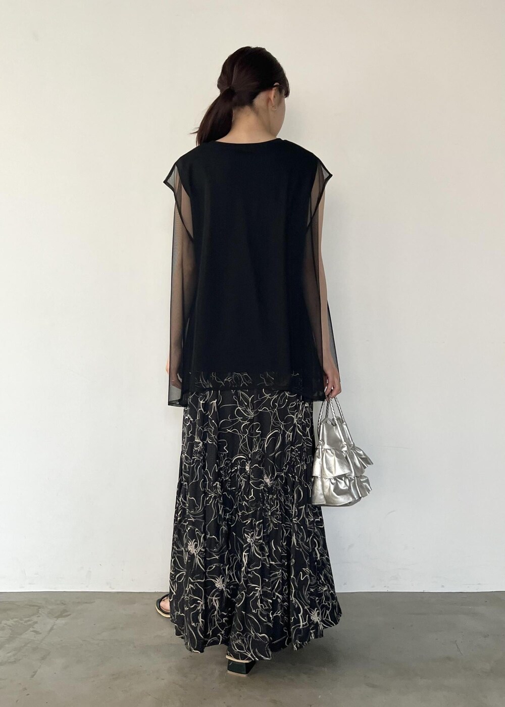 ブラック系のサンダル、ブラック系のTシャツ/カットソー、ブラック系のスカートを着用したレディースの夏コーディネートの3枚目の写真