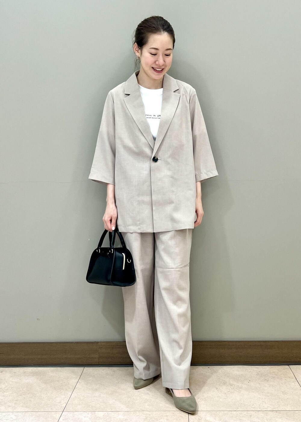 ブラック系のボストンバッグ、ベージュ系のテーラードジャケット、ホワイト系のTシャツ/カットソーを着用したレディースの夏コーディネートの5枚目の写真