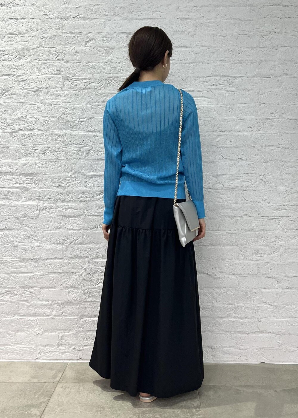 シルバー系のショルダーバッグ、シルバー系のサンダル、ブルー系のカーディガン/ボレロを着用したレディースの秋コーディネートの3枚目の写真