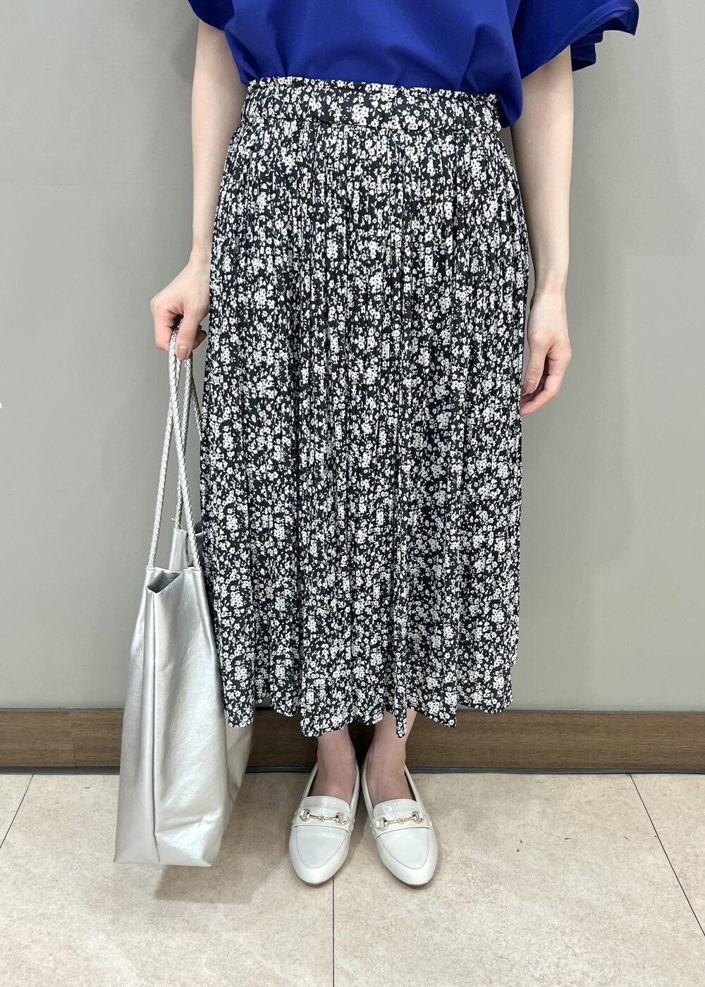 ホワイト系のローファー、シルバー系のトートバッグ、ブラック系のスカートを着用したレディースの夏コーディネートの5枚目の写真