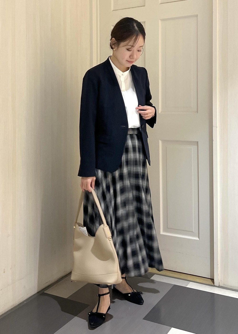 ブルー系のノーカラージャケット、ホワイト系のシャツ/ブラウス、ベージュ系のショルダーバッグを着用したレディースの夏コーディネートの3枚目の写真