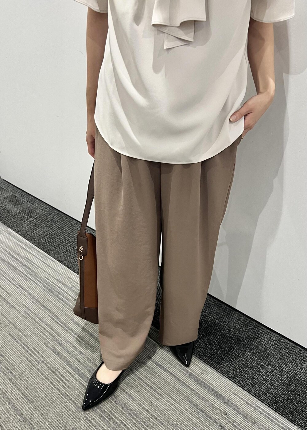 ブラウン系のその他パンツ、ベージュ系のシャツ/ブラウス、ブラック系のパンプスを着用したレディースの夏コーディネートの6枚目の写真