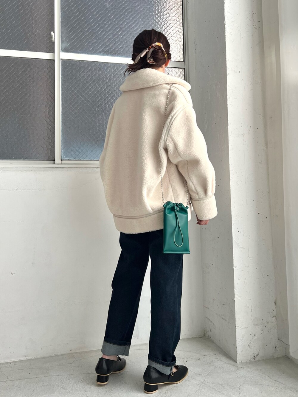 ホワイト系のカーディガン/ボレロ、ホワイト系のムートンコート、ブルー系のデニムパンツを着用したレディースの冬コーディネートの3枚目の写真