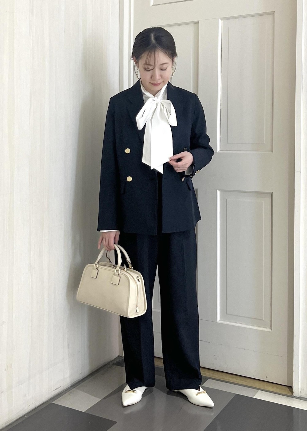 ホワイト系のボストンバッグ、ホワイト系のパンプス、ブルー系のその他パンツを着用したレディースの冬コーディネートの3枚目の写真
