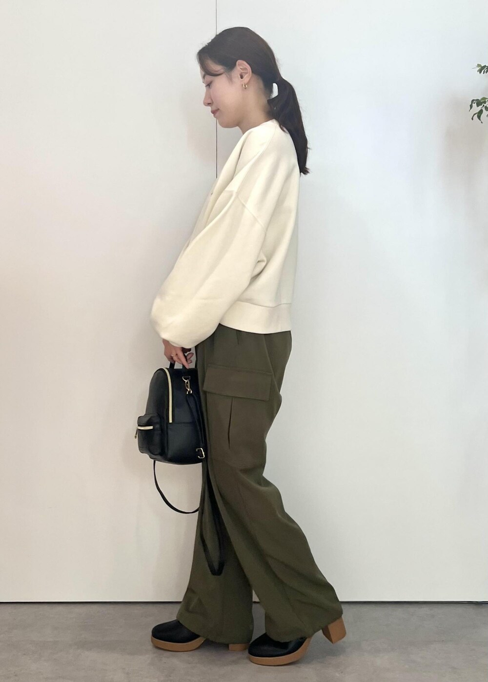 ブラック系のバックパック/リュック、ブラック系のブーツ、ホワイト系のスウェットを着用したレディースの秋コーディネートの5枚目の写真