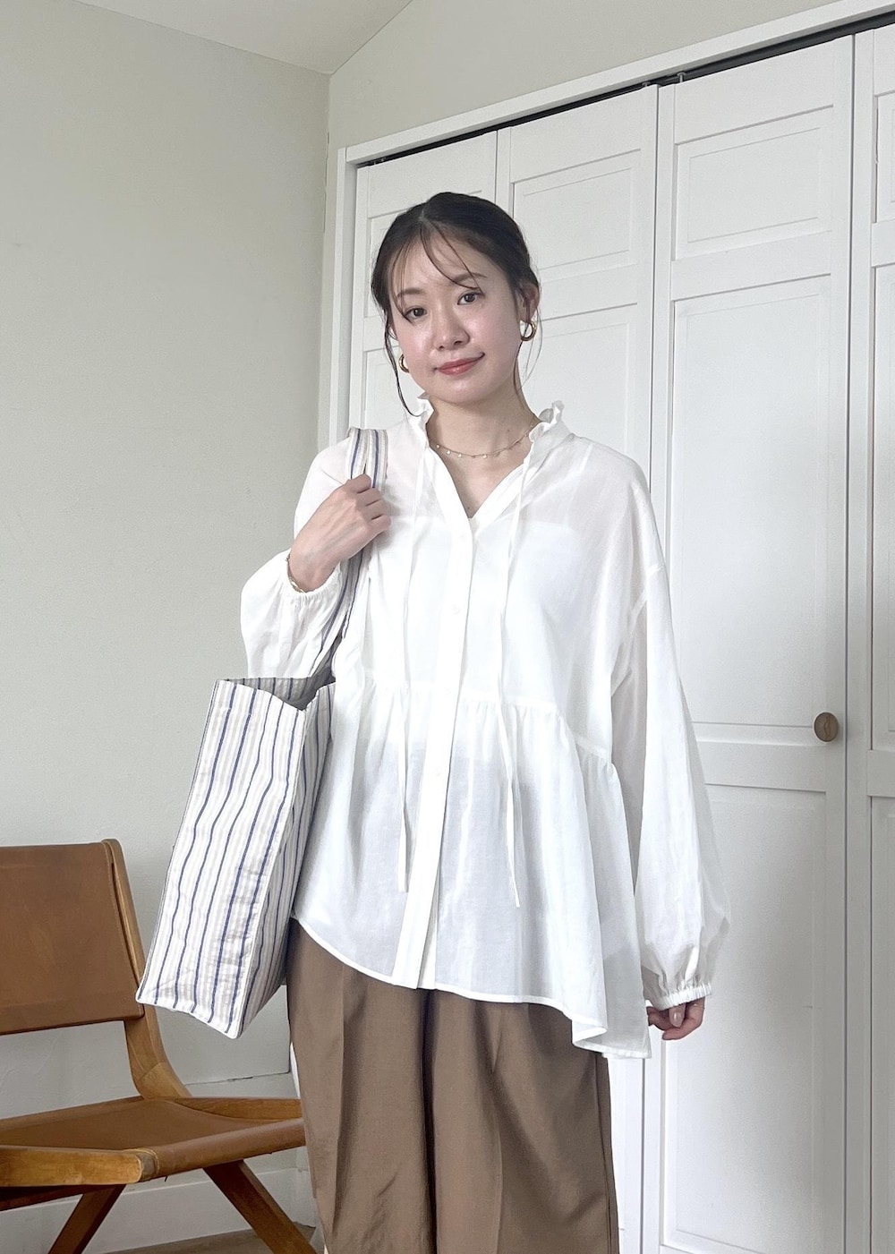 ブルー系のトートバッグ、ホワイト系のシャツ/ブラウス、イエロー系のその他パンツを着用したレディースの春コーディネートの5枚目の写真