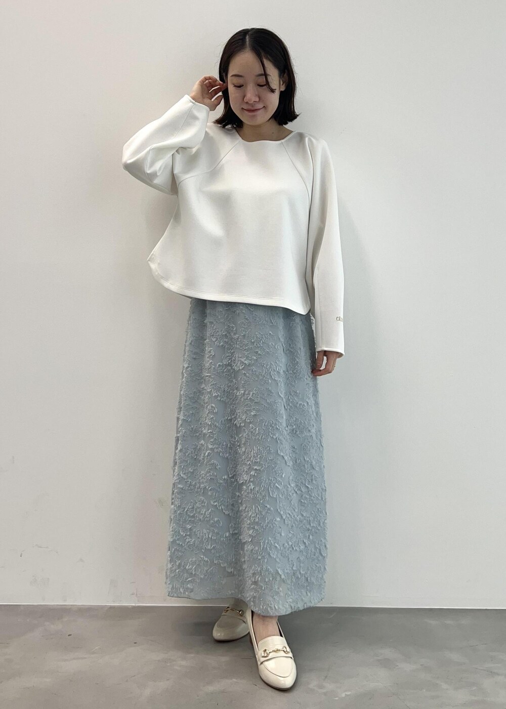 ホワイト系のローファー、ホワイト系のTシャツ/カットソー、ブルー系のスカートを着用したレディースの春コーディネートの3枚目の写真