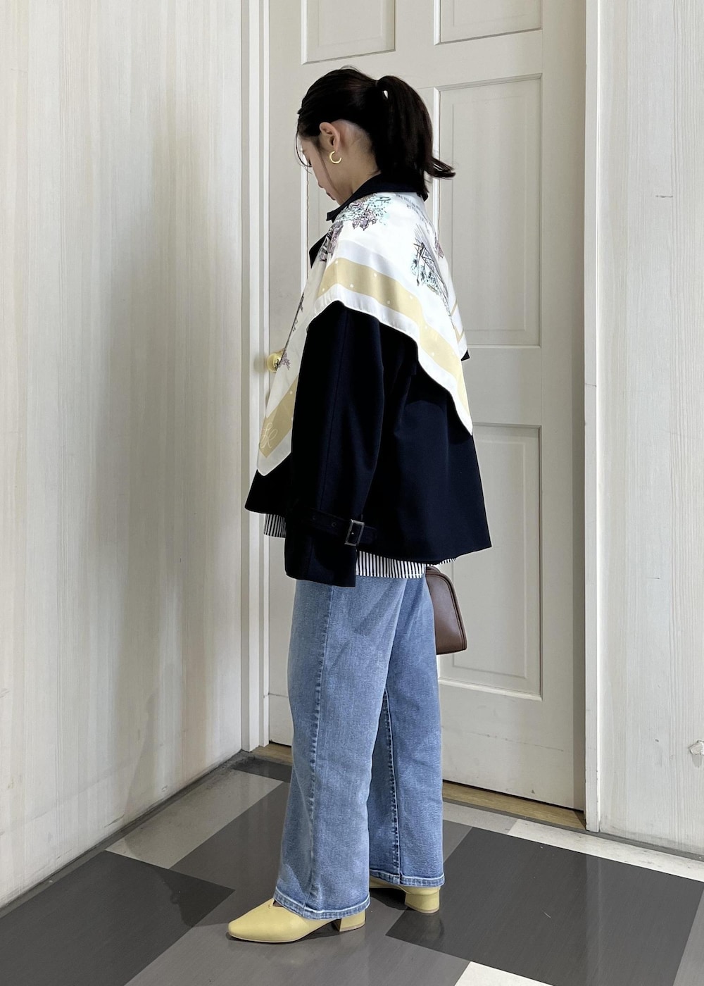 ブラウン系のボストンバッグ、ブルー系のトレンチコート、ブルー系のシャツ/ブラウスを着用したレディースの春コーディネートの3枚目の写真