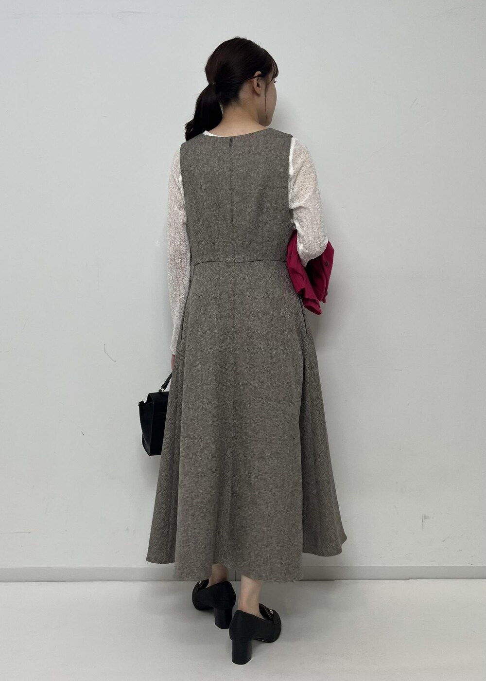 ベージュ系のジャンパースカート、ピンク系のカーディガン/ボレロ、ホワイト系のTシャツ/カットソーを着用したレディースの秋コーディネートの3枚目の写真