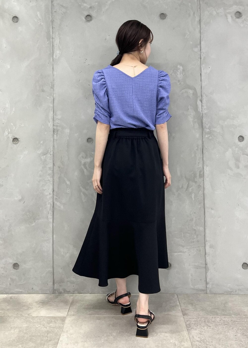 ブルー系のTシャツ/カットソー、ブラック系のサンダル、ブラック系のスカートを着用したレディースの夏コーディネートの3枚目の写真