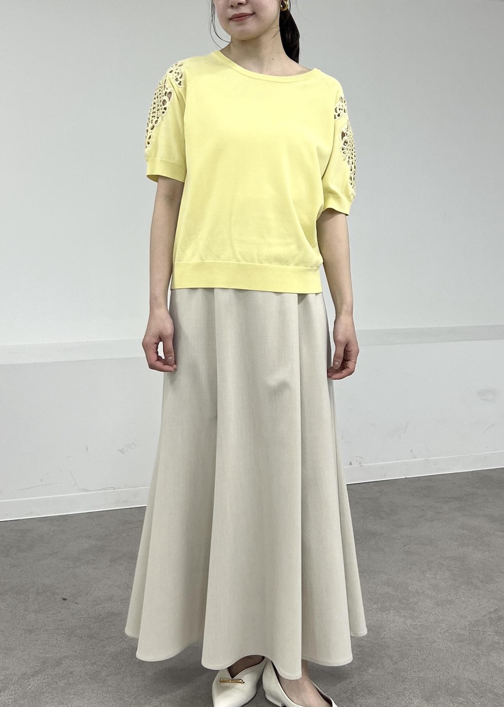 ホワイト系のパンプス、ベージュ系のテーラードジャケット、ベージュ系のスカートを着用したレディースの春コーディネートの8枚目の写真