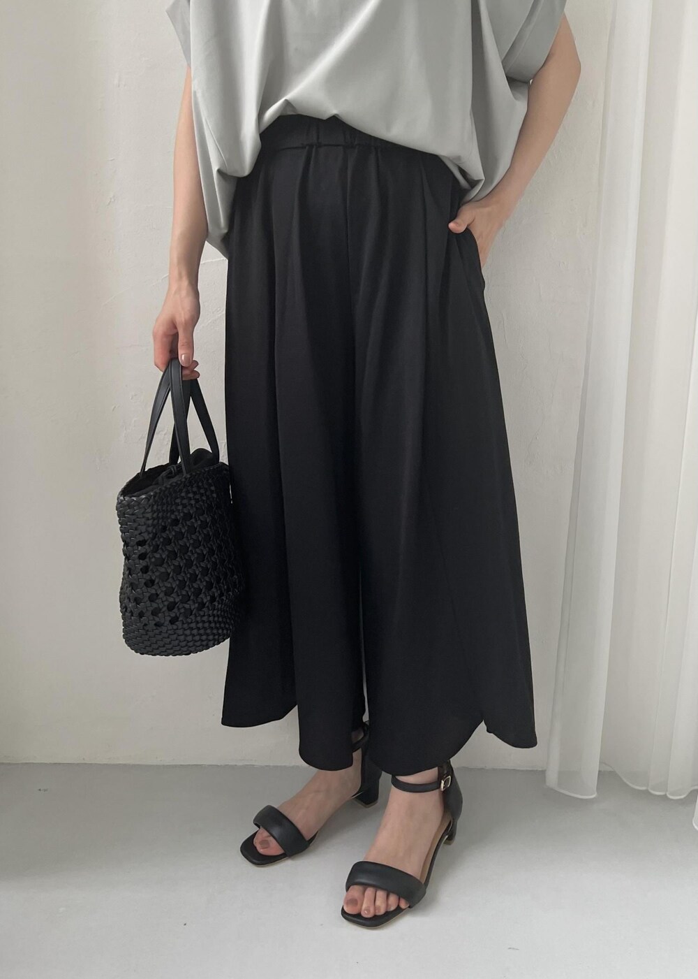 ブラック系のサンダル、ブラック系のトートバッグ、グリーン系のTシャツ/カットソーを着用したレディースの春コーディネートの6枚目の写真