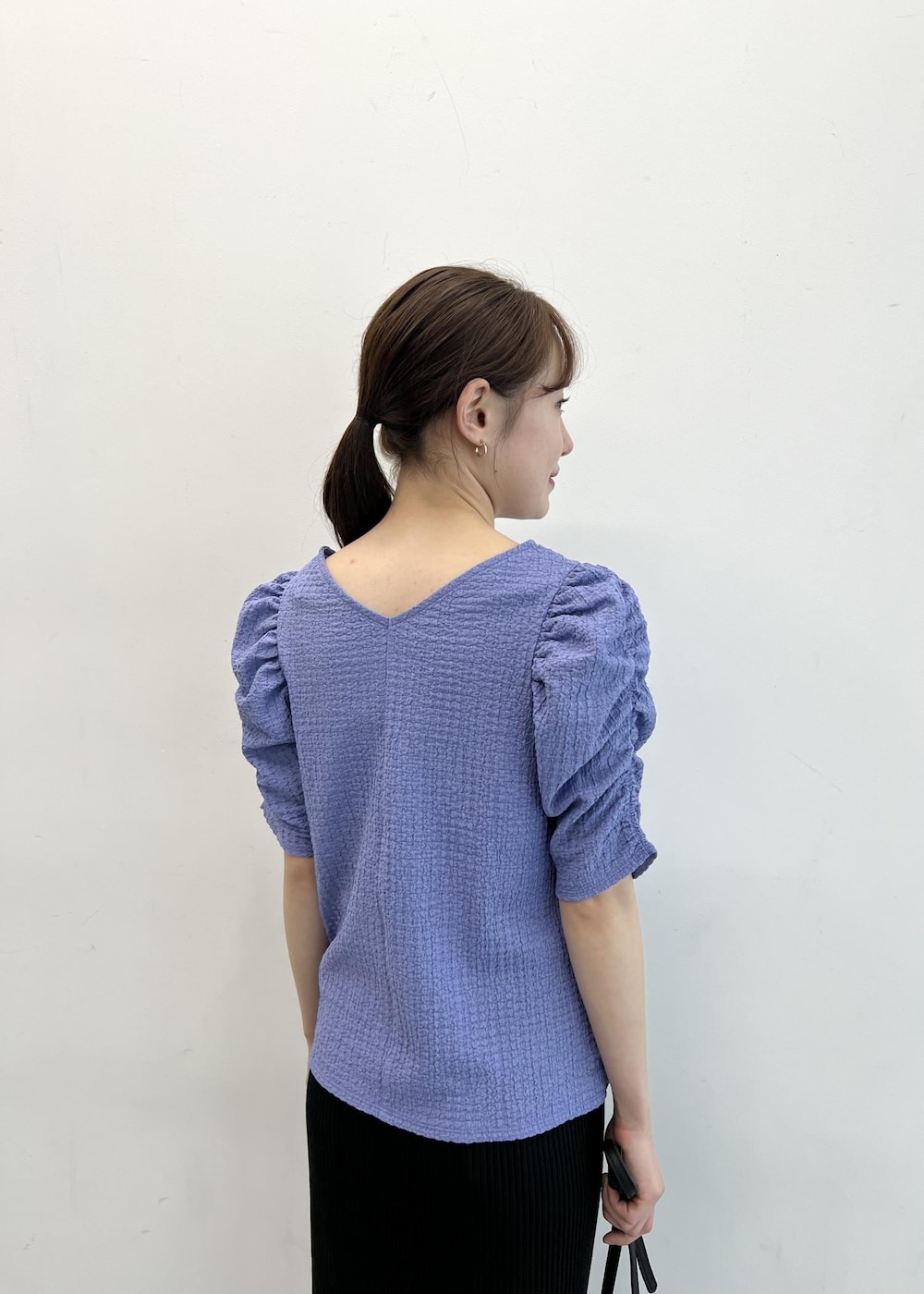 ブラック系のショルダーバッグ、ブルー系のTシャツ/カットソー、ブラック系のスカートを着用したレディースの夏コーディネートの7枚目の写真