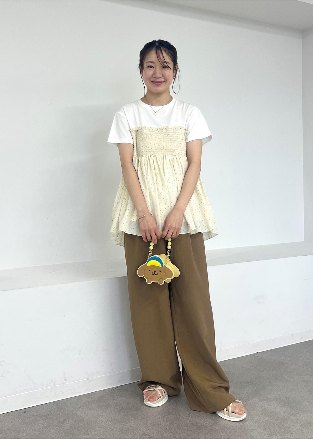 イエロー系のその他パンツ、ホワイト系のサンダル、ブラック系のTシャツ/カットソーを着用したレディースの夏コーディネートの2枚目の写真