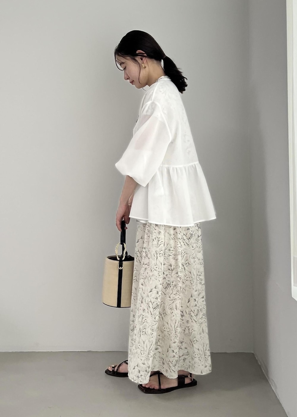 ホワイト系のブルゾン、ブラック系のサンダル、ホワイト系のワンピースを着用したレディースの春コーディネートの3枚目の写真