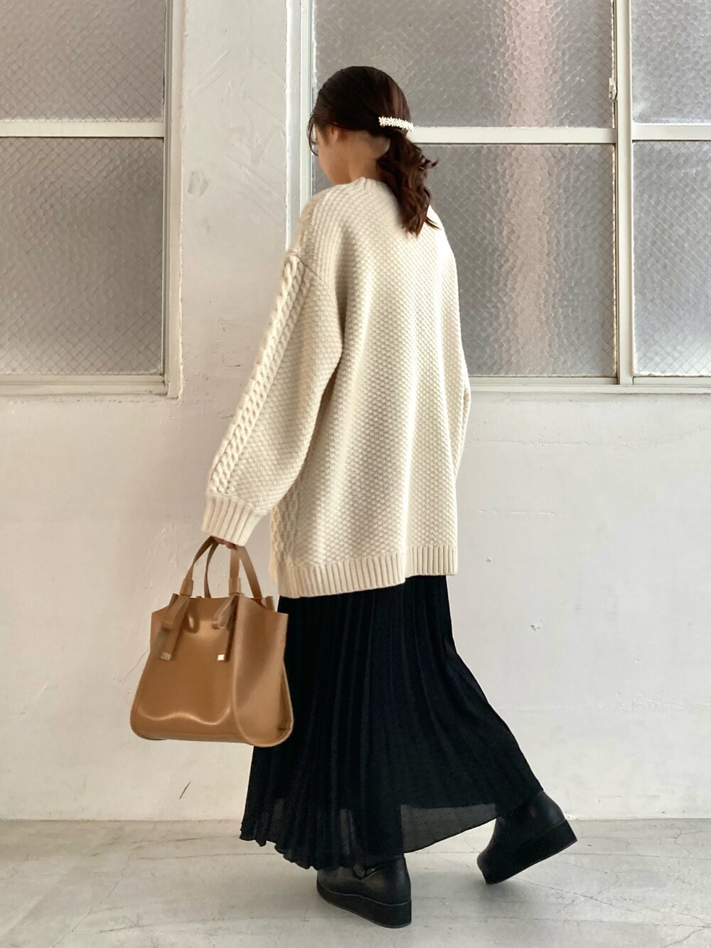 ホワイト系のニット/セーター、ブラック系のスカート、ブラック系のブーツを着用したレディースの冬コーディネートの2枚目の写真