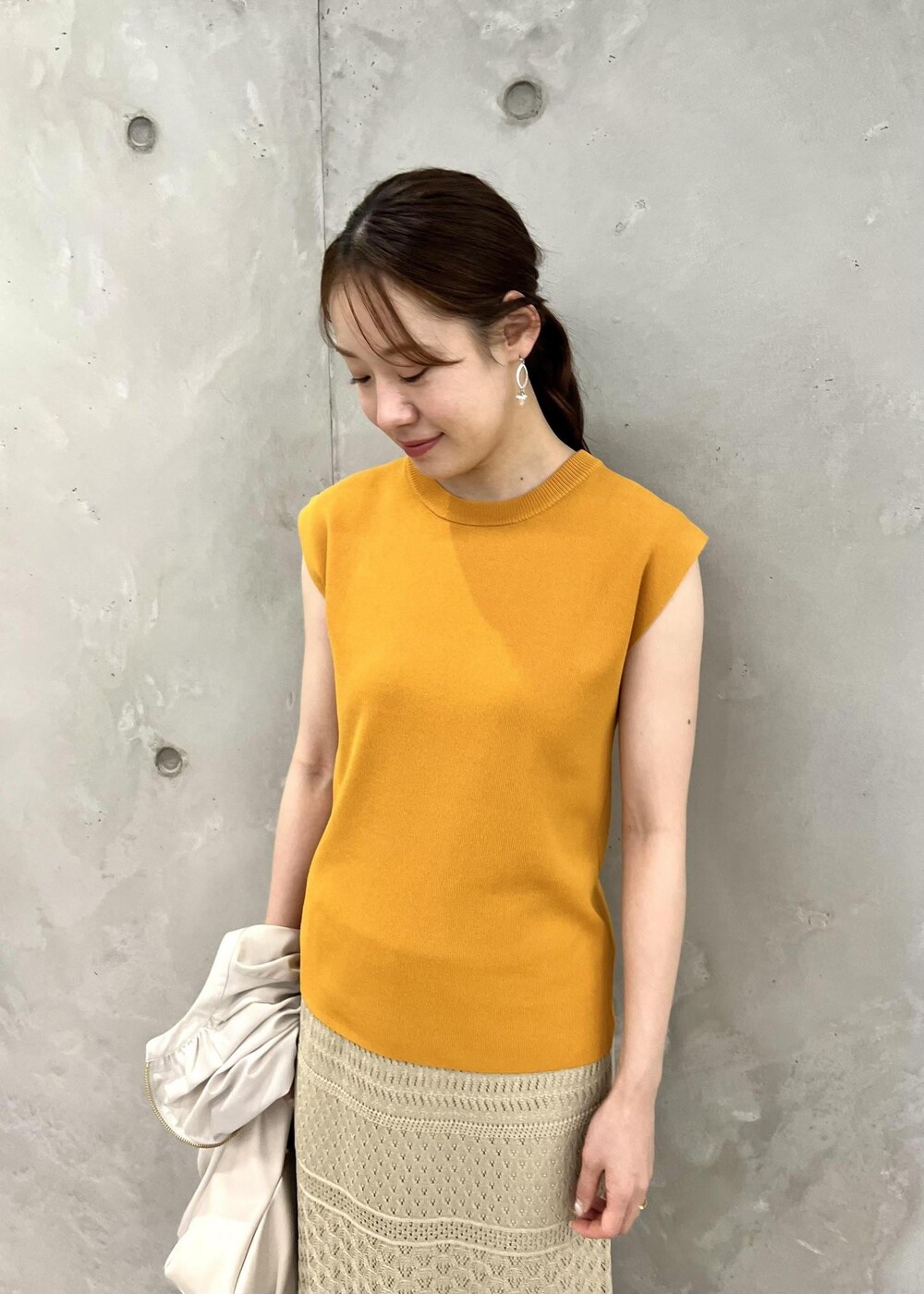 ベージュ系のサンダル、ベージュ系のブルゾン、オレンジ系のニット/セーターを着用したレディースの春コーディネートの7枚目の写真