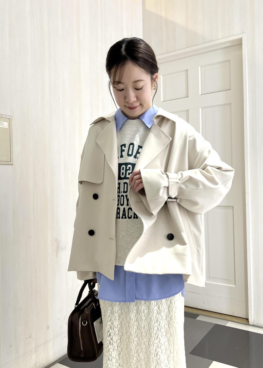 ブラウン系のボストンバッグ、ベージュ系のパンプス、ホワイト系のスウェットを着用したレディースの冬コーディネートの7枚目の写真