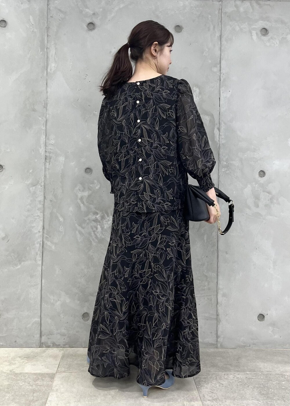 ブルー系のパンプス、ブラック系のショルダーバッグ、ブラック系のシャツ/ブラウスを着用したレディースの夏コーディネートの3枚目の写真