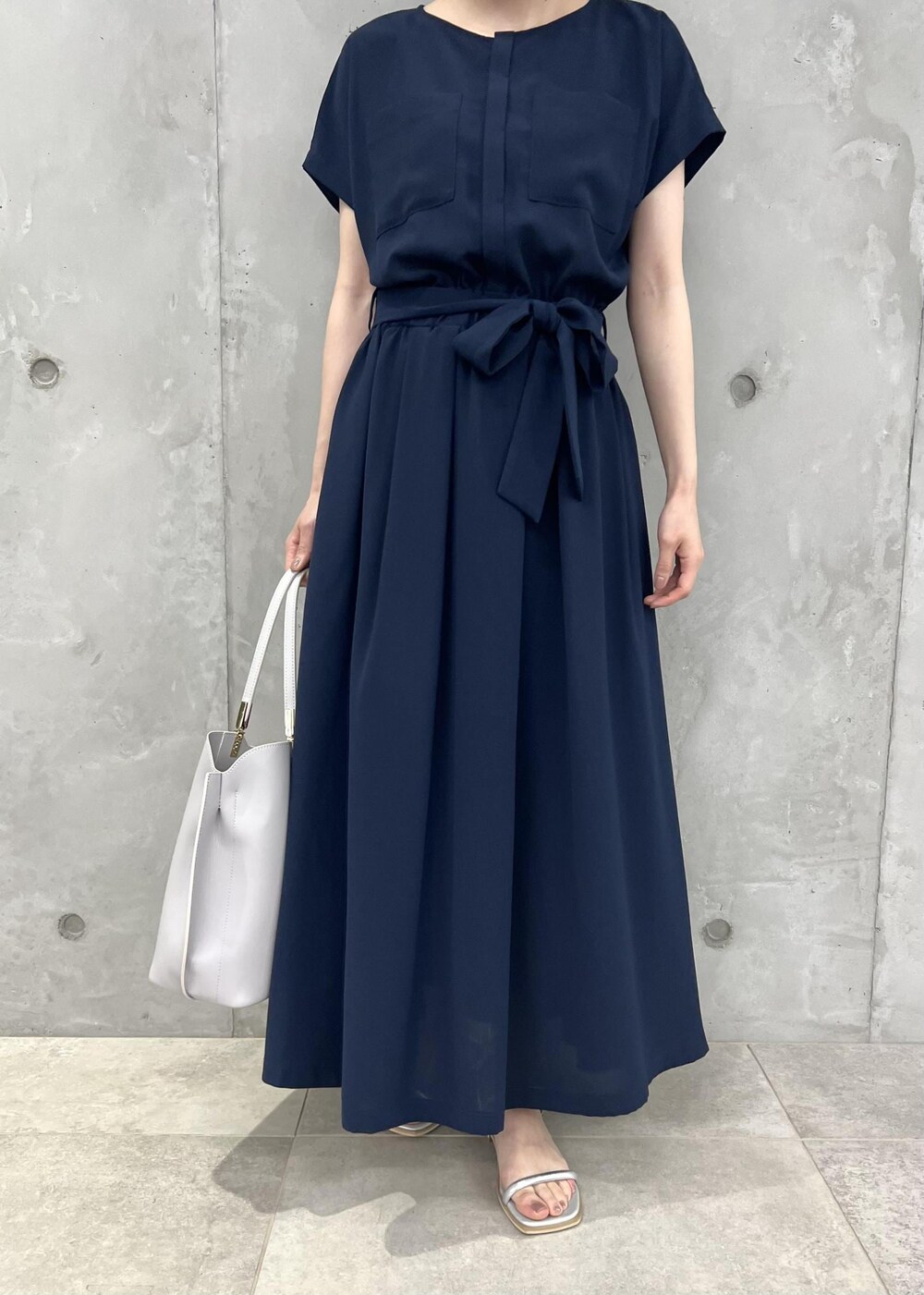 シルバー系のサンダル、ブルー系のワンピース、グレー系のトートバッグを着用したレディースの夏コーディネートの5枚目の写真