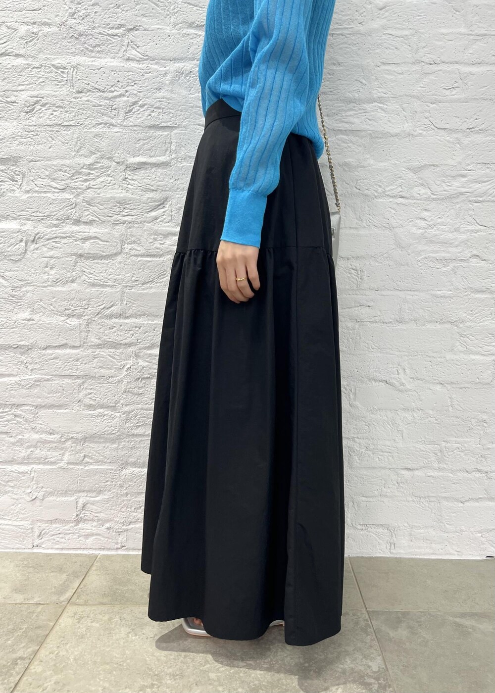 シルバー系のショルダーバッグ、シルバー系のサンダル、ブルー系のカーディガン/ボレロを着用したレディースの秋コーディネートの6枚目の写真