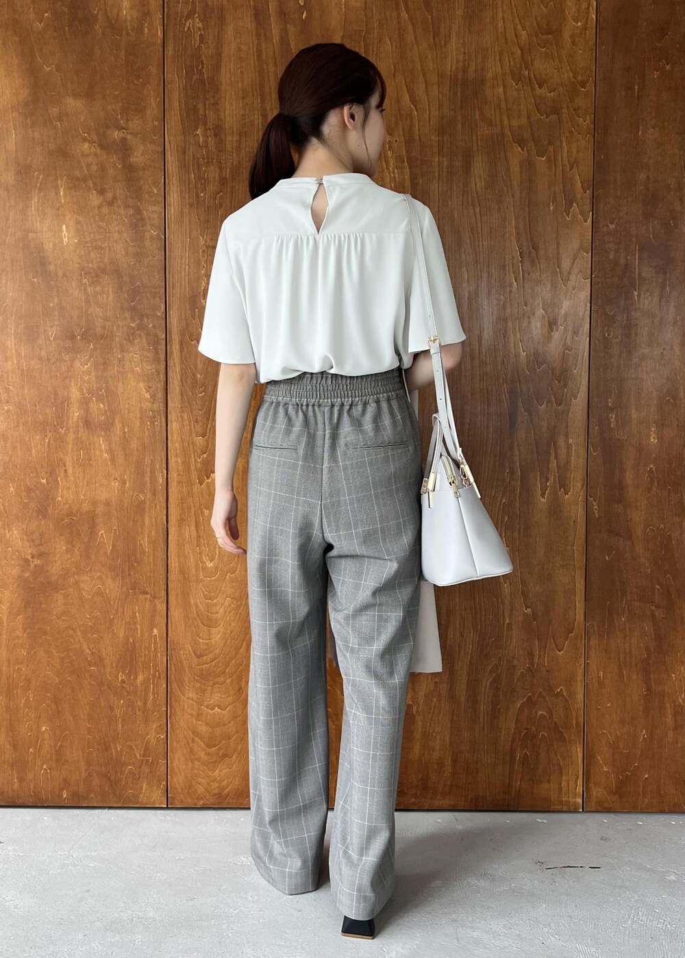 ブラック系のサンダル、ベージュ系のジャンパースカート、ホワイト系のシャツ/ブラウスを着用したレディースの夏コーディネートの3枚目の写真