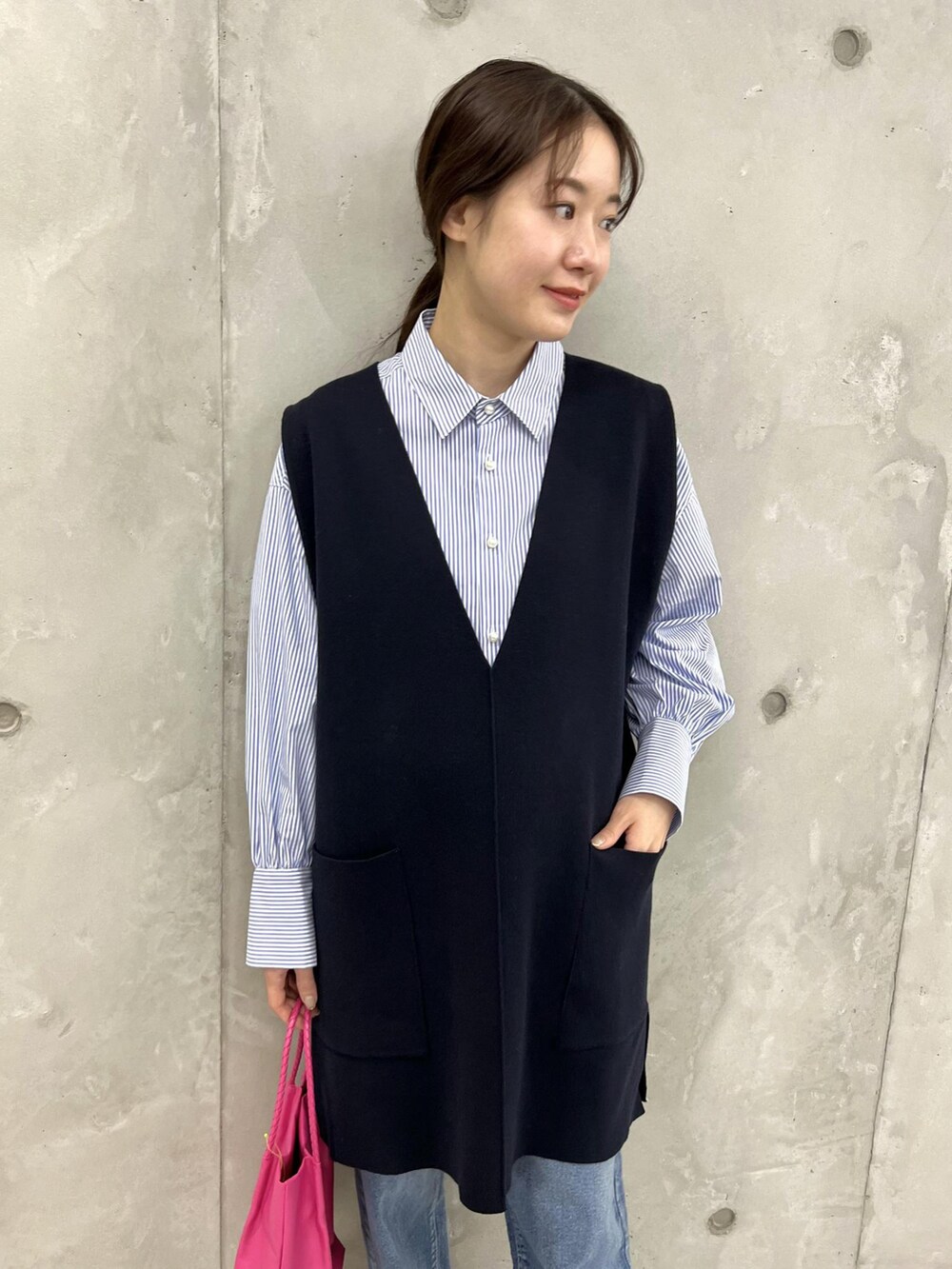 ブルー系のベスト、ブルー系のサンダル、ピンク系のトートバッグを着用したレディースの春コーディネートの4枚目の写真