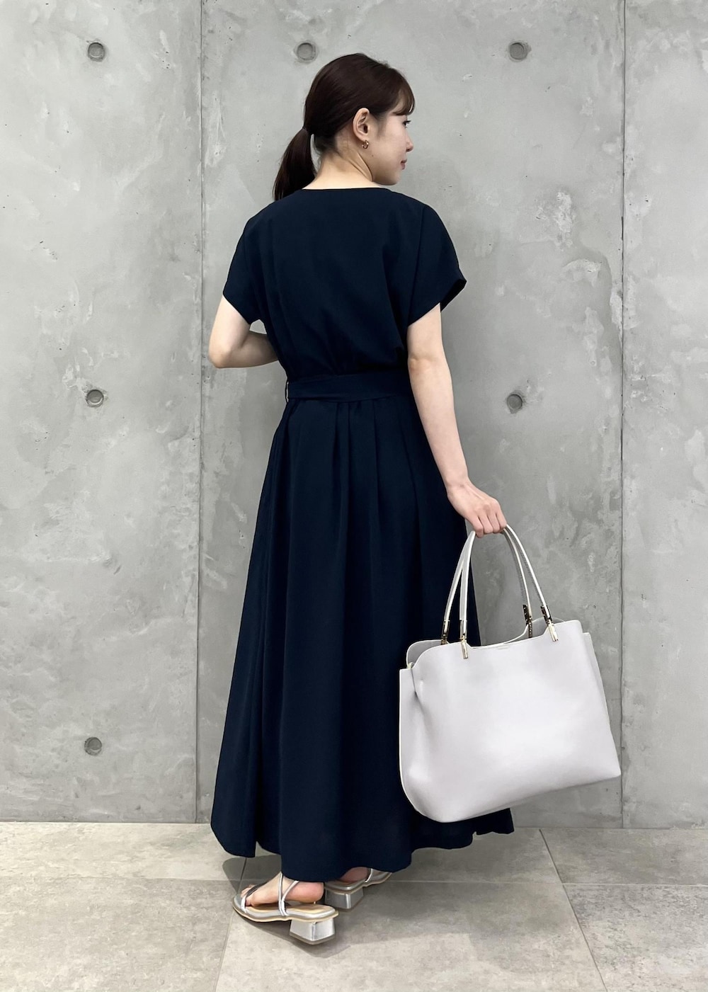 シルバー系のサンダル、ブルー系のワンピース、グレー系のトートバッグを着用したレディースの夏コーディネートの3枚目の写真