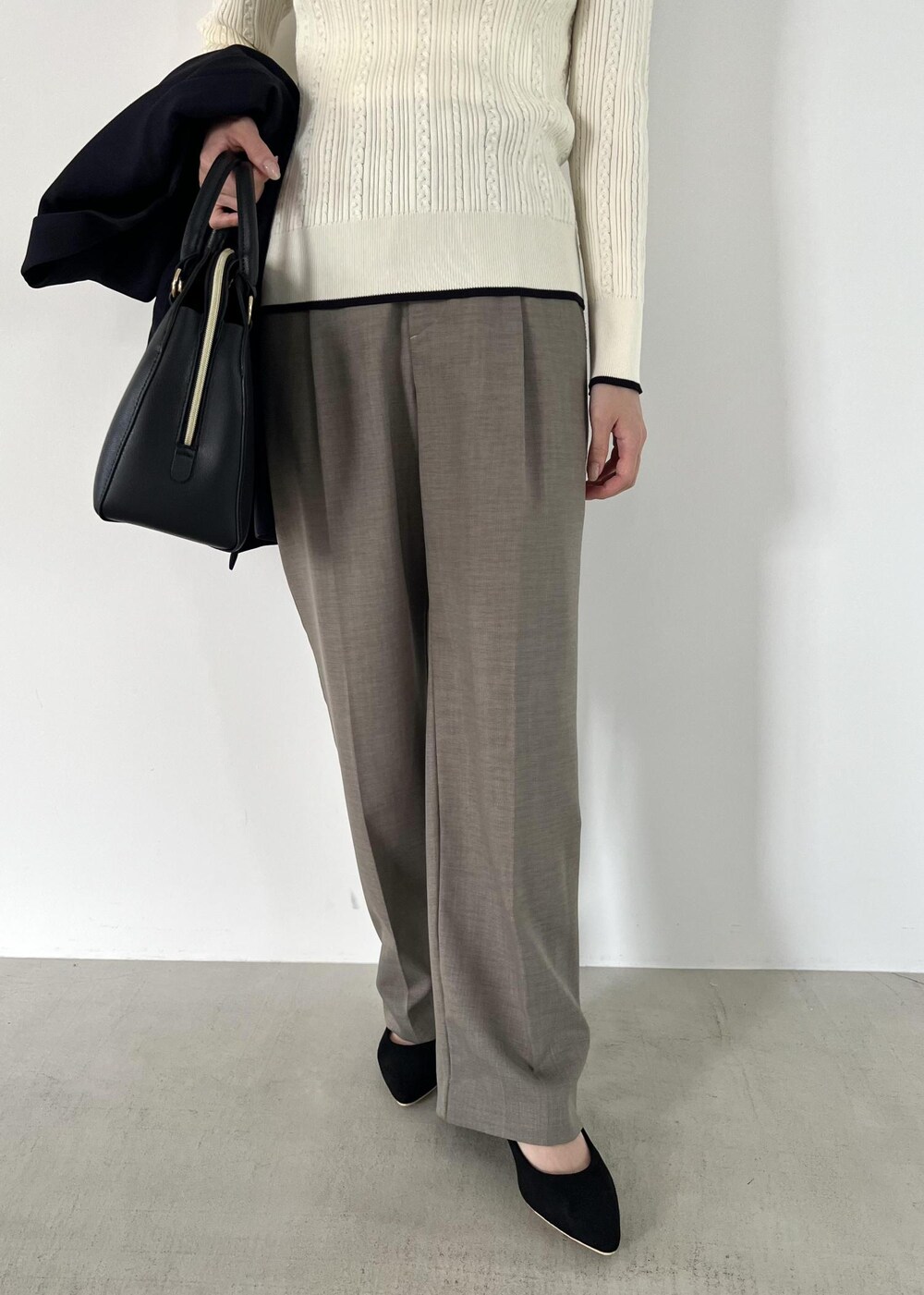 ブラック系のボストンバッグ、ブルー系のテーラードジャケット、ホワイト系のニット/セーターを着用したレディースの秋コーディネートの7枚目の写真