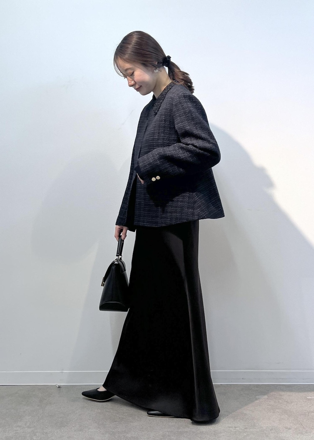 ブルー系のノーカラージャケット、ブラック系のショルダーバッグ、ブルー系のニット/セーターを着用したレディースの冬コーディネートの3枚目の写真