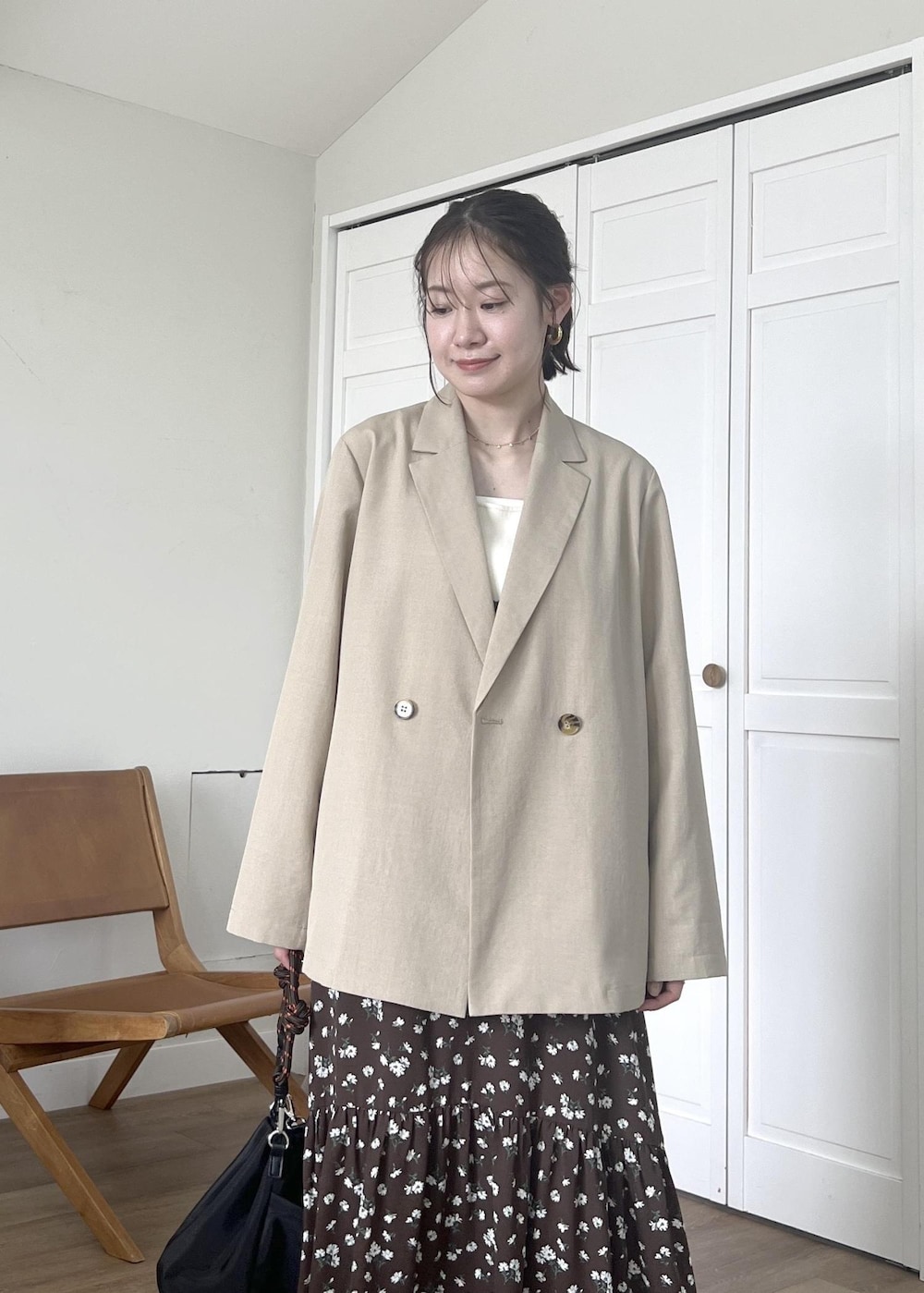 ブルー系のデニムパンツ、ブラック系のショルダーバッグ、ホワイト系のタンクトップを着用したレディースの春コーディネートの4枚目の写真