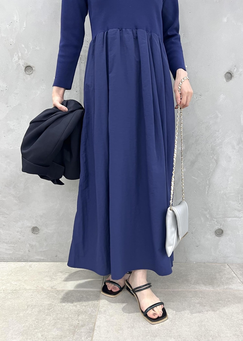 ブルー系のテーラードジャケット、ブラック系のサンダル、ブルー系のワンピースを着用したレディースの夏コーディネートの8枚目の写真