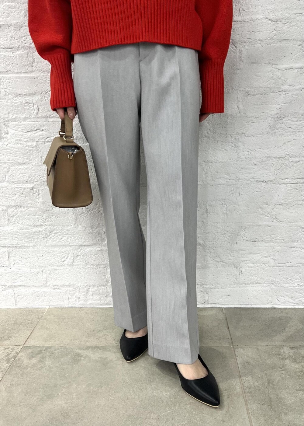 レッド系のニット/セーター、グレー系のその他パンツ、ブラック系のパンプスを着用したレディースの秋コーディネートの5枚目の写真