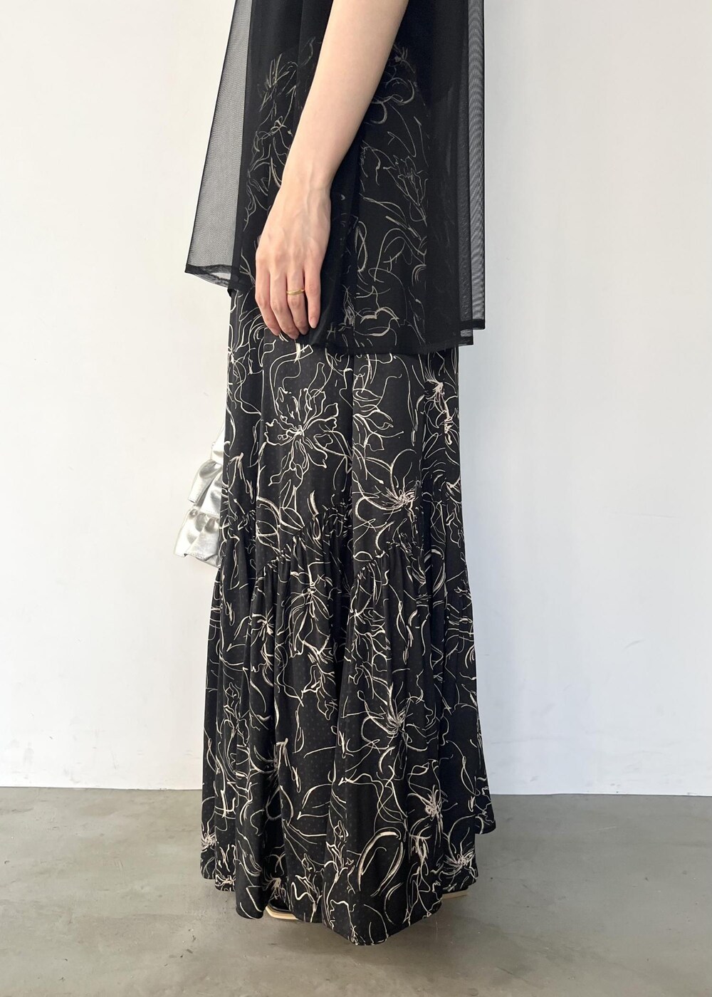 ブラック系のサンダル、ブラック系のTシャツ/カットソー、ブラック系のスカートを着用したレディースの夏コーディネートの7枚目の写真