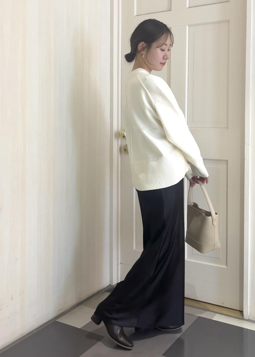 ホワイト系のニット/セーター、ブラウン系のその他アウター、ベージュ系のショルダーバッグを着用したレディースの冬コーディネートの3枚目の写真