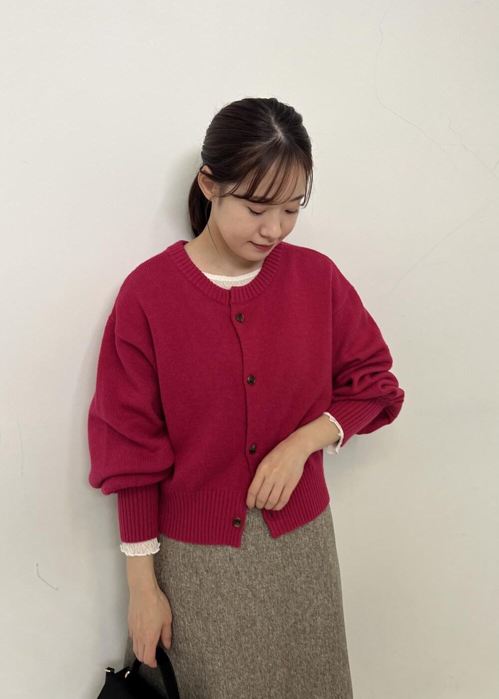 ベージュ系のジャンパースカート、ピンク系のカーディガン/ボレロ、ホワイト系のTシャツ/カットソーを着用したレディースの秋コーディネートの5枚目の写真