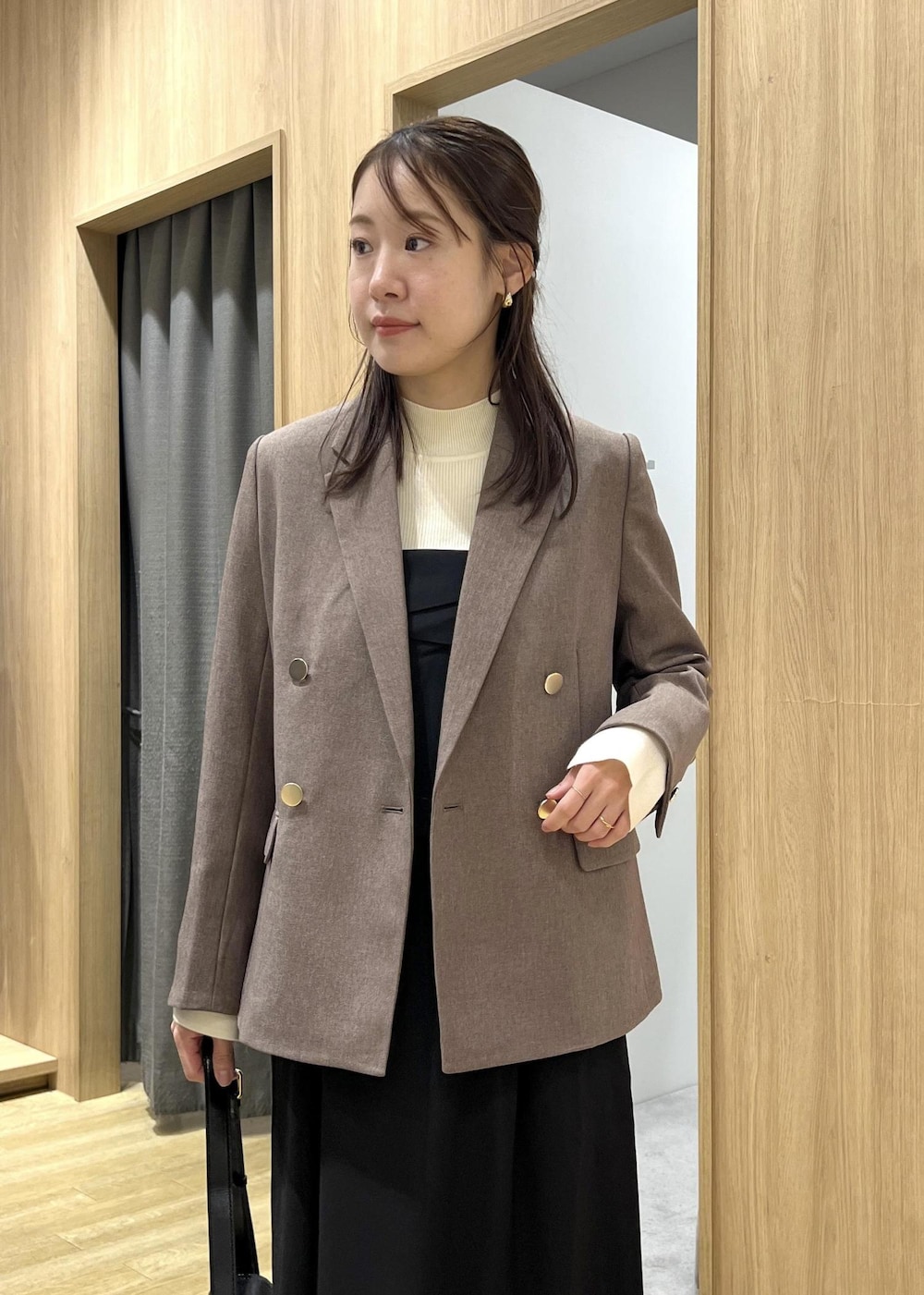 ブラック系のショルダーバッグ、ホワイト系のニット/セーター、ブラック系のワンピースを着用したレディースの秋コーディネートの5枚目の写真
