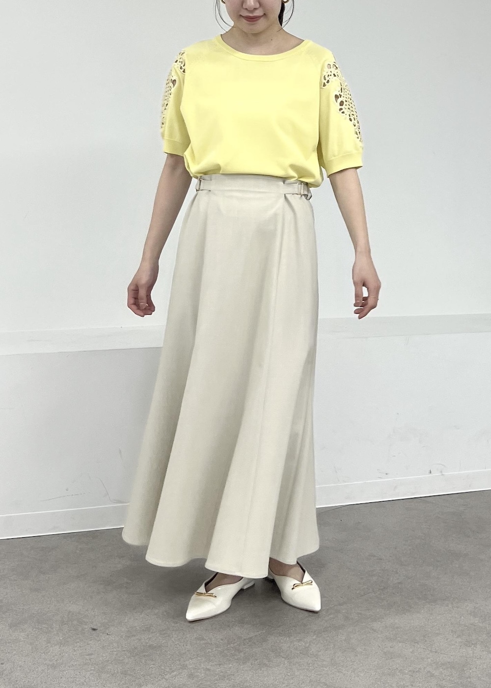 ホワイト系のパンプス、ベージュ系のテーラードジャケット、ベージュ系のスカートを着用したレディースの春コーディネートの6枚目の写真