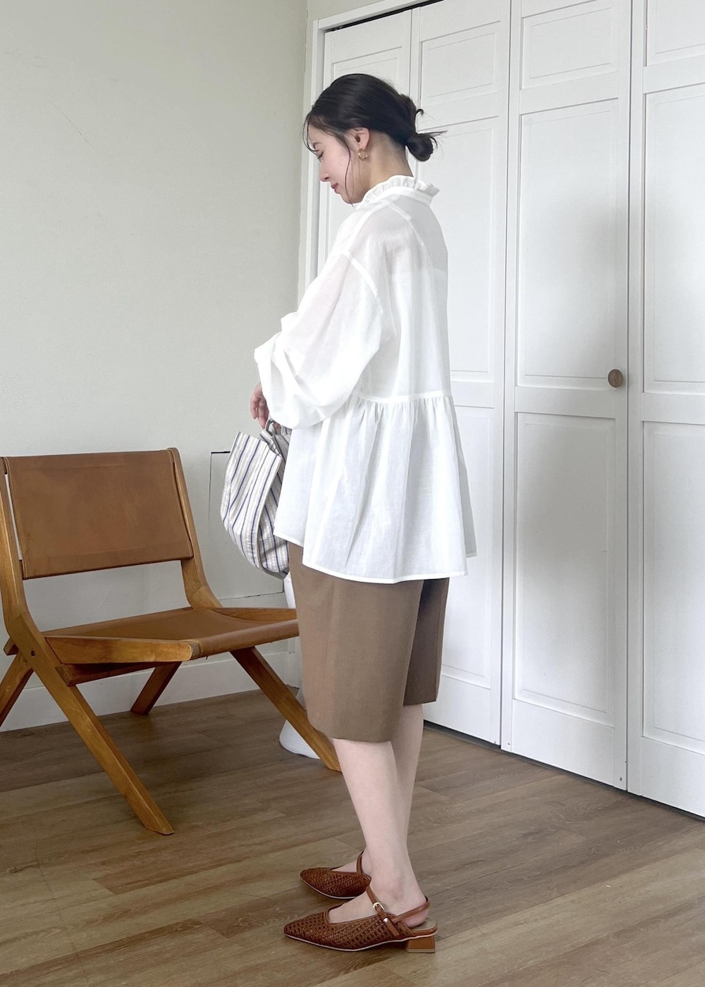 ブルー系のトートバッグ、ホワイト系のシャツ/ブラウス、イエロー系のその他パンツを着用したレディースの春コーディネートの3枚目の写真