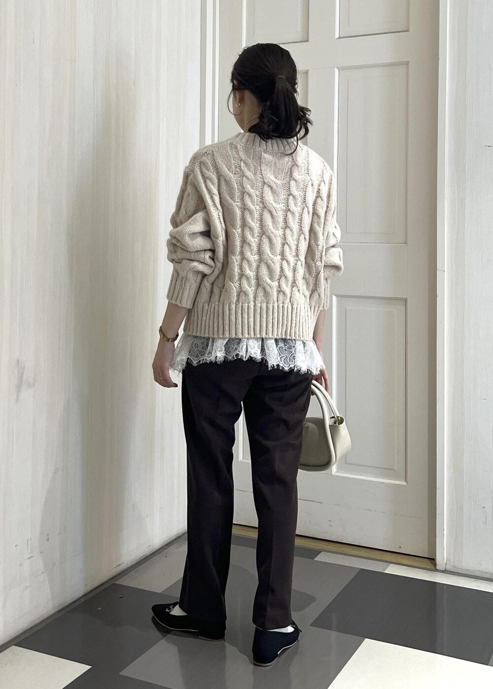 ブラック系のパンプス、ホワイト系のショルダーバッグ、ブラウン系のその他パンツを着用したレディースの冬コーディネートの3枚目の写真