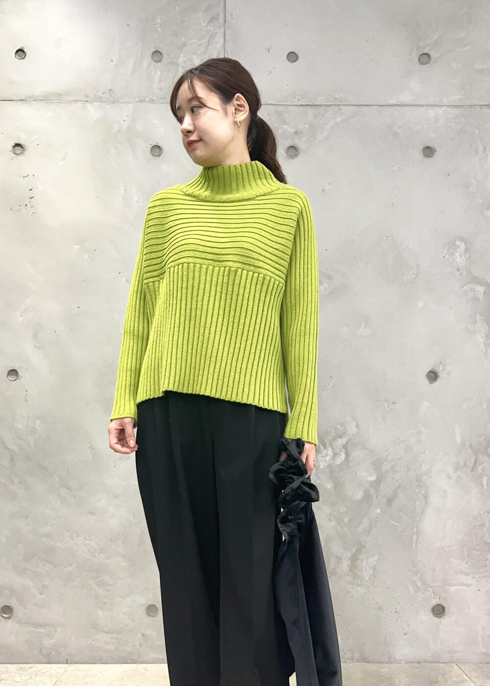 グリーン系のニット/セーター、ブラック系のショルダーバッグ、ブラック系のその他パンツを着用したレディースの秋コーディネートの4枚目の写真