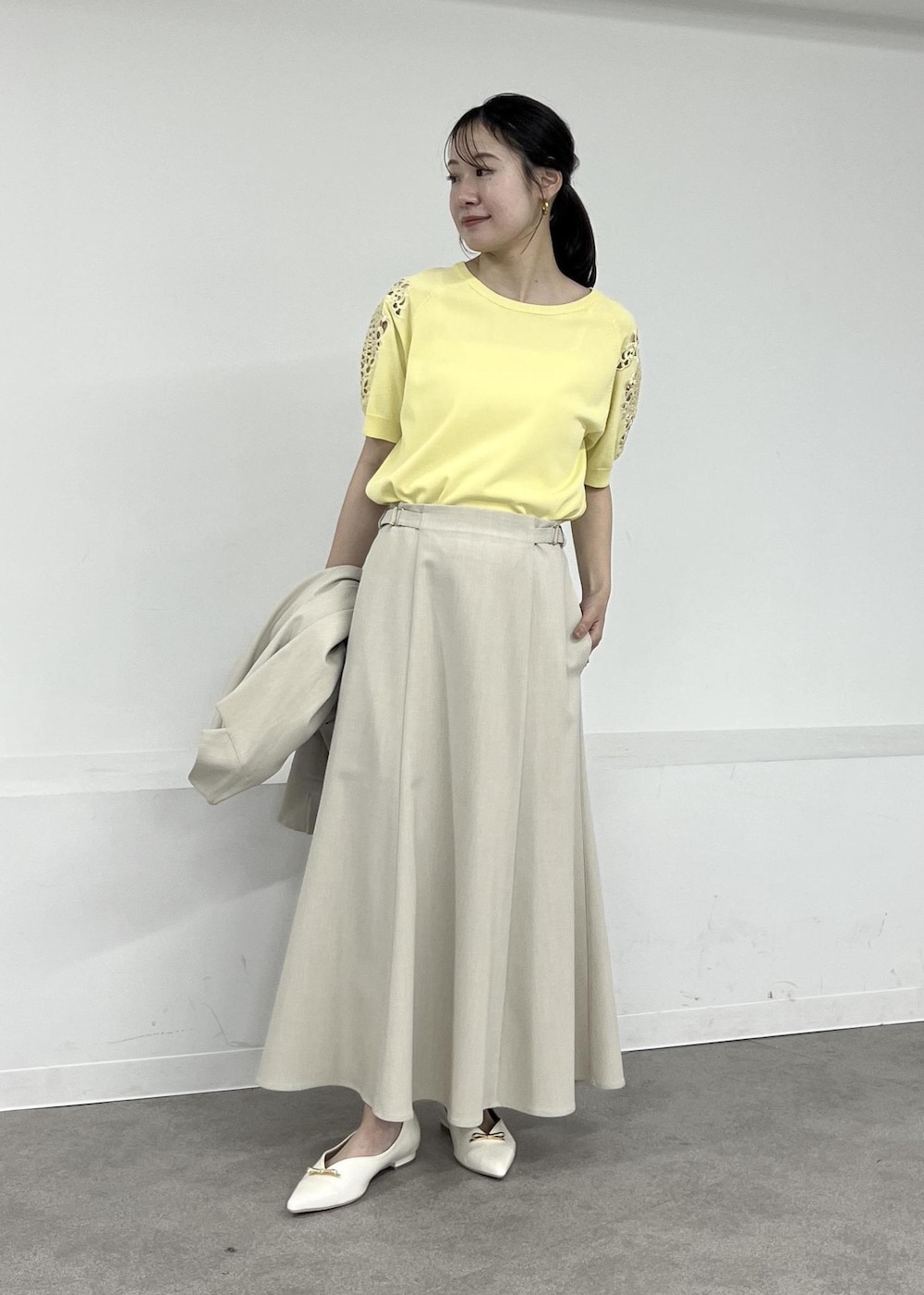 ホワイト系のパンプス、ベージュ系のテーラードジャケット、ベージュ系のスカートを着用したレディースの春コーディネートの4枚目の写真