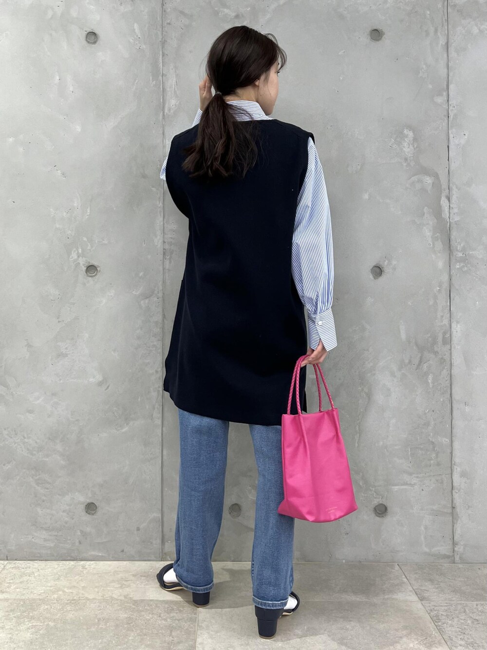 ブルー系のベスト、ブルー系のサンダル、ピンク系のトートバッグを着用したレディースの春コーディネートの3枚目の写真