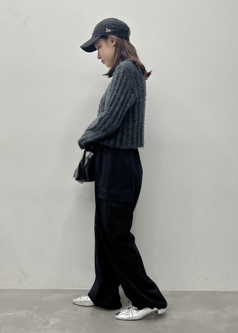 ブラック系のカーゴパンツ、グレー系のカーディガン/ボレロ、ブラック系のショルダーバッグを着用したレディースの冬コーディネートの2枚目の写真