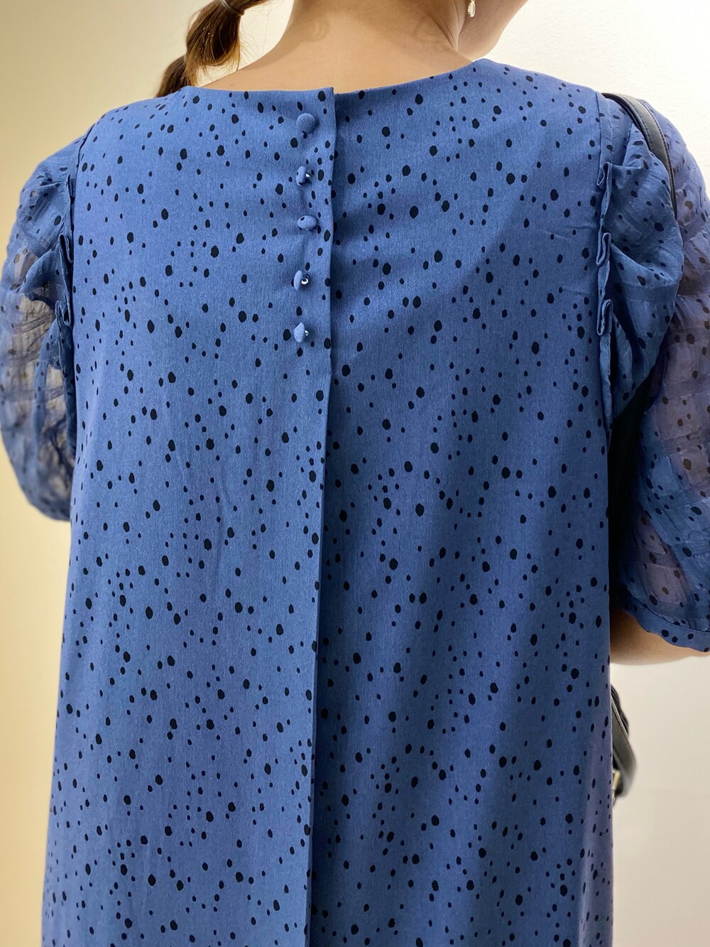 ブラック系のショルダーバッグ、シルバー系のサンダル、ブルー系のワンピースを着用したレディースの夏コーディネートの4枚目の写真