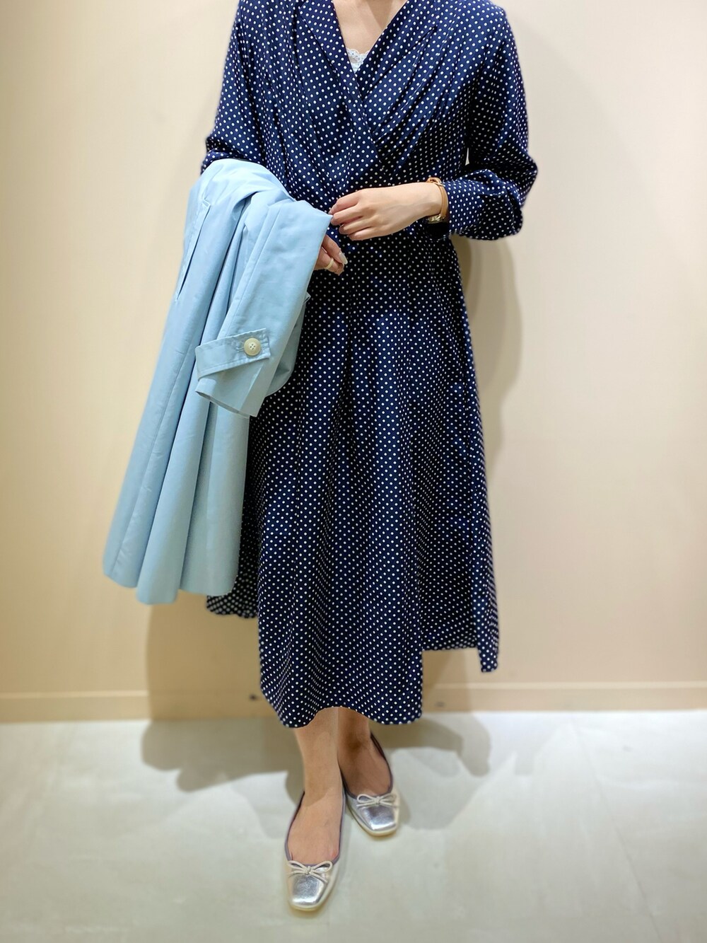 シルバー系のパンプス、ブルー系のステンカラーコート、ブルー系のワンピースを着用したレディースの春コーディネートの2枚目の写真