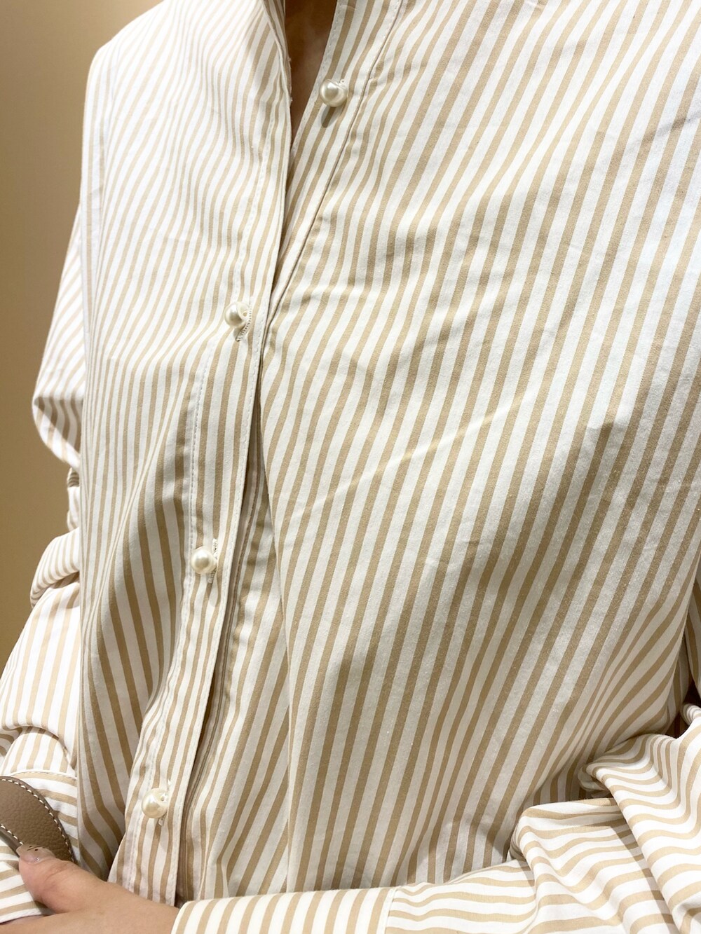 ブラウン系のショルダーバッグ、ブラウン系のパンプス、ベージュ系のシャツ/ブラウスを着用したレディースの春コーディネートの4枚目の写真