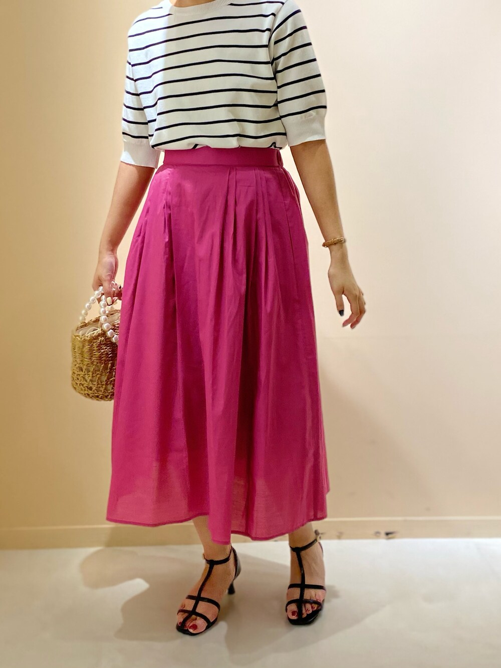 ブラック系のサンダル、ベージュ系のトートバッグ、ホワイト系のニット/セーターを着用したレディースの夏コーディネートの2枚目の写真