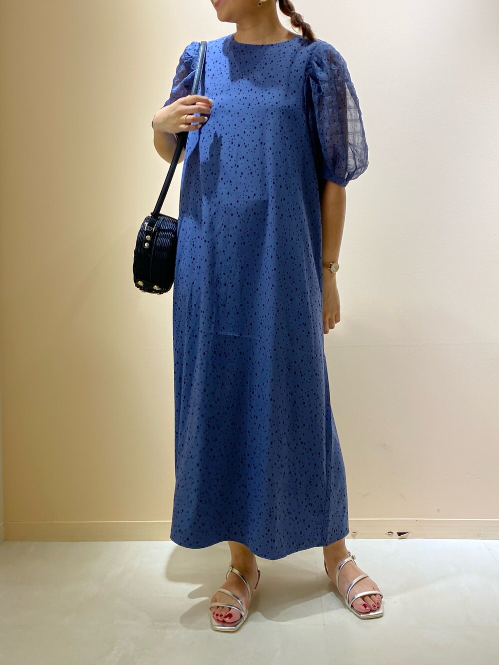 ブラック系のショルダーバッグ、シルバー系のサンダル、ブルー系のワンピースを着用したレディースの夏コーディネートの2枚目の写真