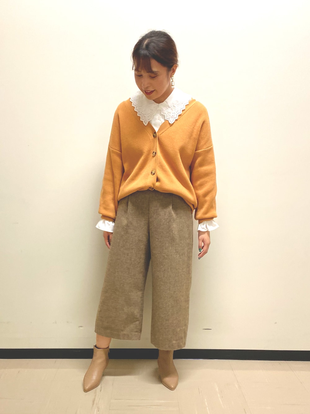 ブラウン系のその他パンツ、オレンジ系のカーディガン/ボレロ、ベージュ系のブーツを着用したレディースの秋コーディネートの2枚目の写真